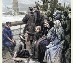 Immigrants crowded on a ship deck viewing the Statue of Liberty as they arrive in New York Harbor.