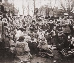 Crowd of Eastern European emigrants, possibly Jewish, with three Russian officials, who are reviewing their travel papers. ca. 1912.