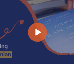 Educational video thumbnail titled “Being Iranian” featuring a close-up of a blue book cover with a play button overlay, set against a dark blue graphic background with decorative arrow and circular design elements.